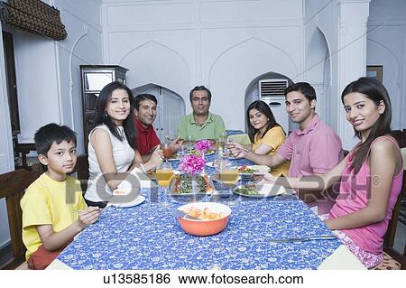Stock Photograph - Portrait of a group of people sitting at a dining table. Fotosearch
