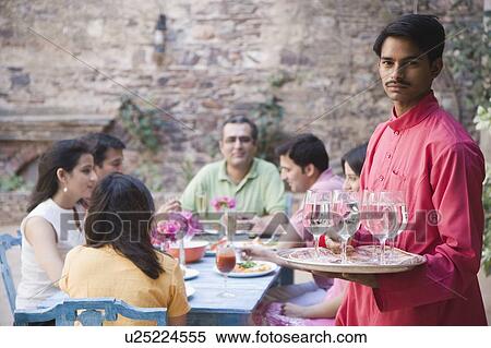 Portrait of a waiter serving water to guests View Large Photo Image Stock Photography - Portrait of a waiter serving water to guests. Fotosearch