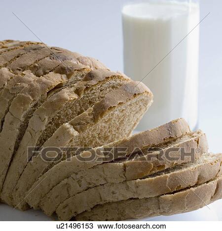 Stock Image - Close-up of a glass of milk with brown bread. Fotosearch