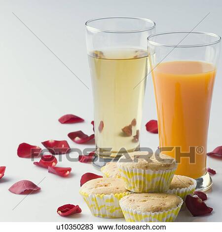 Close-up of a glass of orange juice with cupcakes View Large Photo Image Stock Image - Close-up of a glass of orange juice with cupcakes. Fotosearch