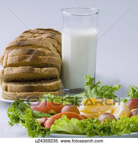 Stock Photography - Close-up of fruits and vegetables in a plate with a glass of milk. Fotosearch
