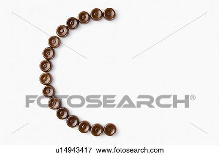 Stock Photo - High angle view of brown candies arranged in the form of letter c. Fotosearch