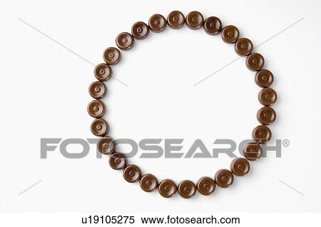 Stock Photography - High angle view of brown candies arranged in the form of a circle. Fotosearch