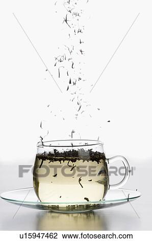 Stock Image - Tea leaves floating in a cup of herbal tea. Fotosearch