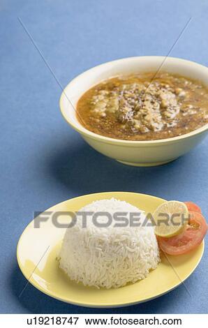 Stock Photo - Close-up of a plate of rice with a bowl of curry. Fotosearch