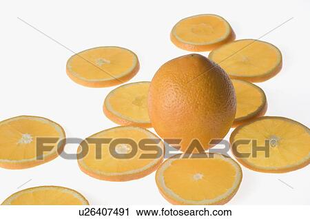 Stock Image - Close-up of an orange between orange slices. Fotosearch