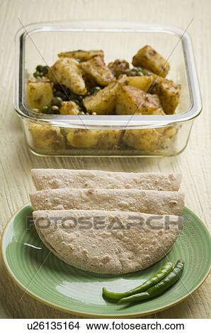 Close-up of chapattis in a plate with a bowl of potato sabzi View Large Photo Image Picture - Close-up of chapattis in a plate with a bowl of potato sabzi. Fotosearch