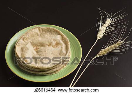 Picture - Close-up of chapattis in a plate with wheat husks. Fotosearch