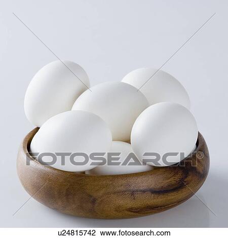 Stock Image - Close-up of eggs in a wooden bowl. Fotosearch