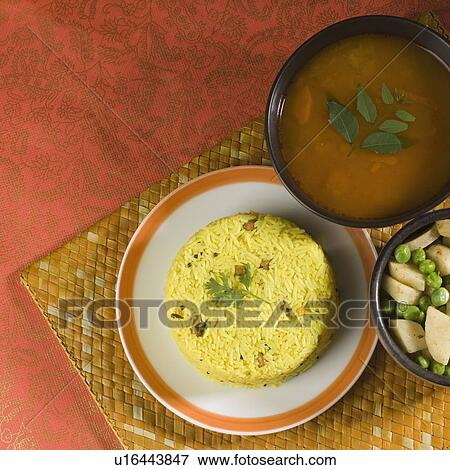 High angle view of rice in a plate with daal and fried peas and potato slices in a bowl View Large Photo Image Stock Photo - High angle view of rice in a plate with daal and fried peas and potato slices in a bowl. Fotosearch