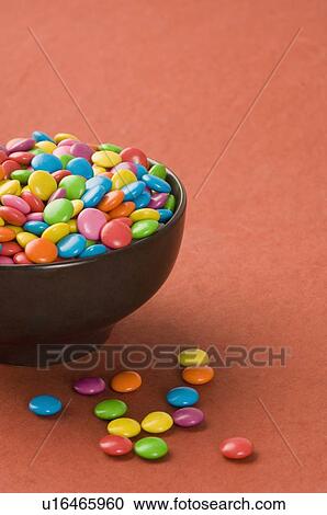 Candies assorted near a bowl of candies View Large Photo Image Stock Image - Candies assorted near a bowl of candies. Fotosearch