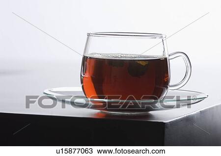 Stock Image - Close-up of a cup of herbal tea on a saucer. Fotosearch