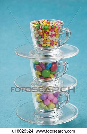 Picture - Jellybeans and candies in a stack of cups saucers. Fotosearch