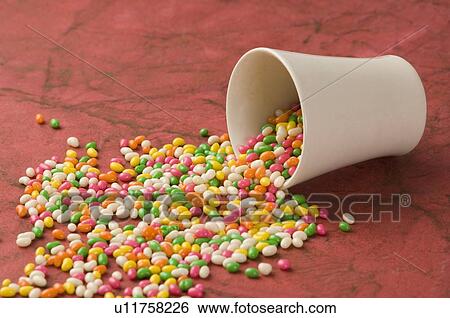 Stock Photograph - Jellybeans spilling from a glass. Fotosearch