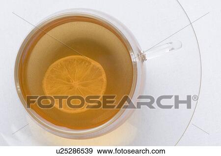 Stock Photo - Slice of lemon in a cup of herbal tea. Fotosearch