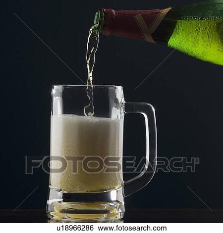Stock Photograph - Beer being poured into a beer glass. Fotosearch