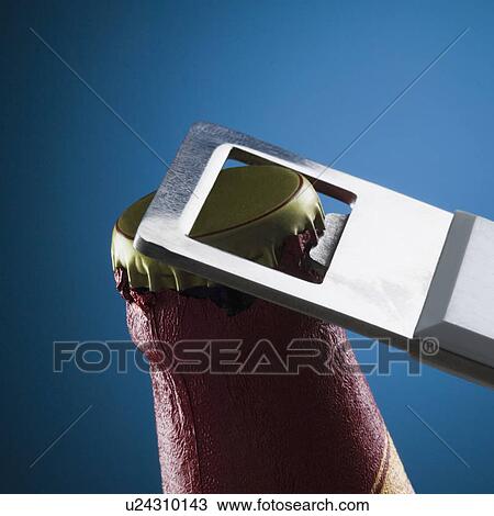 Stock Image - Close-up of a beer bottle and a beer opener. Fotosearch