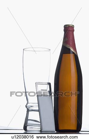 Stock Photograph - Close-up of a beer bottle with a glass and a bottle opener. Fotosearch