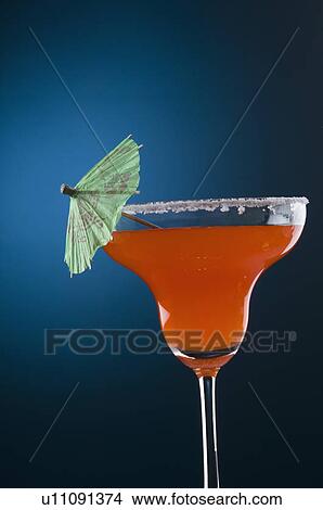 Picture - Close-up of a drink umbrella on a glass of margarita. Fotosearch