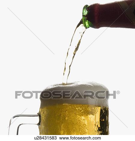Stock Image - Close-up of beer being poured into a beer glass. Fotosearch