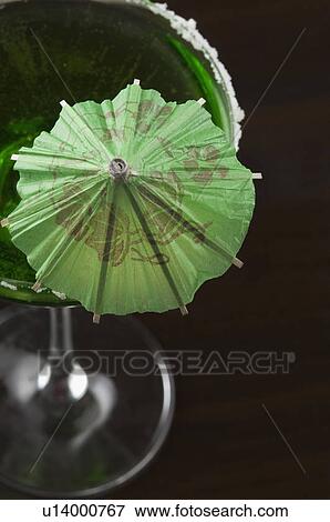 Stock Photo - High angle view of a drink umbrella on a glass of margarita. Fotosearch
