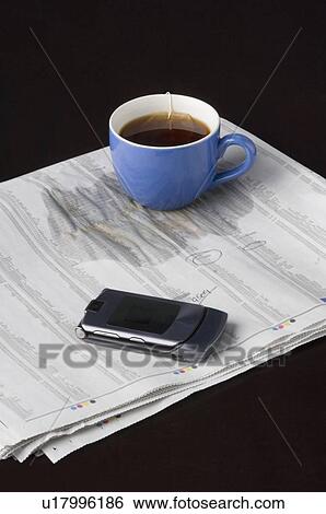 Close-up of a cup of tea on a document with a mobile phone View Large Photo Image Stock Photograph - Close-up of a cup of tea on a document with a mobile phone. Fotosearch