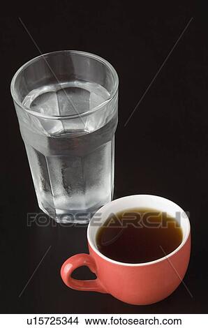 Close-up of a cup of tea with a glass of water View Large Photo Image Picture - Close-up of a cup of tea with a glass of water. Fotosearch