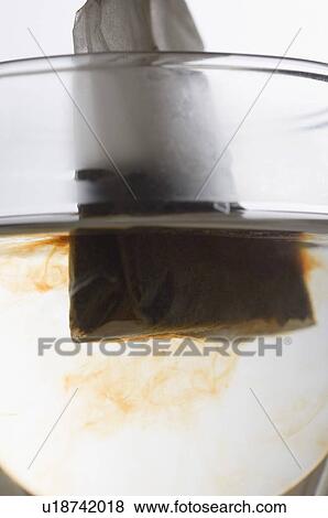 Close-up of a teabag dipped in a cup of herbal tea View Large Photo Image Stock Photo - Close-up of a teabag dipped in a cup of herbal tea. Fotosearch