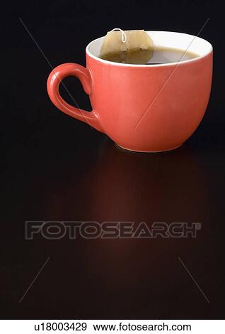 Stock Photo - Close-up of a teabag in a cup of tea. Fotosearch