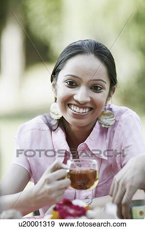 Close-up of a teenage girl holding a cup of tea and smiling View Large Photo Image Stock Photo - Close-up of a teenage girl holding a cup of tea and smiling. Fotosearch