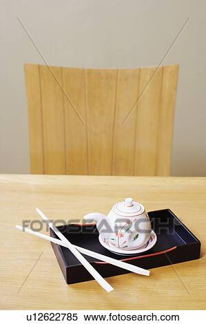 Stock Photography - High angle view of a tea kettle with a pair of chopsticks on a tray. Fotosearch