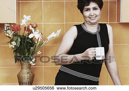 Stock Photograph - Portrait of a mature woman holding a mug. Fotosearch