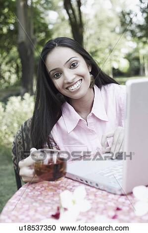 Stock Image - Portrait of a teenage girl sitting in front of a laptop. Fotosearch