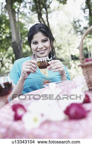 Picture - Portrait of a young woman holding a cup of black tea. Fotosearch