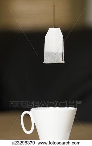 Teabag hanging over a tea cup View Large Photo Image Stock Photo - Teabag hanging over a tea cup. Fotosearch