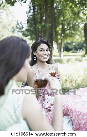Picture - Two young women holding cups of tea. Fotosearch