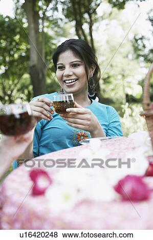 Young woman holding a cup of black tea View Large Photo Image Stock Photo - Young woman holding a cup of black tea. Fotosearch