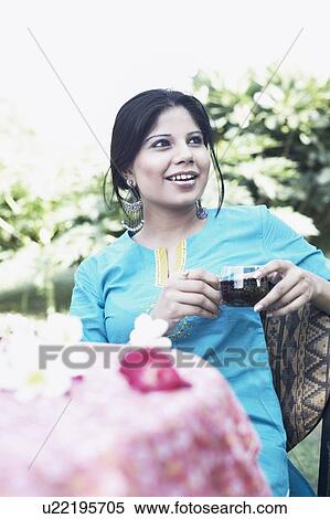 Stock Photography - Young woman holding a cup of black tea. Fotosearch