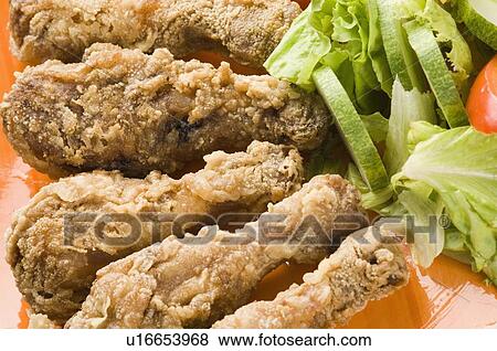 Stock Photo - Close-up of fried chicken drumsticks and salad in a plate. Fotosearch