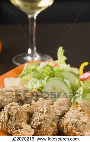 Stock Photograph - Close-up of fried chicken drumsticks and salad in a plate. Fotosearch