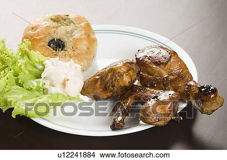 Close-up of roast chicken with a bun in a plate View Large Photo Image Picture - Close-up of roast chicken with a bun in a plate. Fotosearch