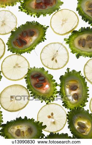 Stock Image - Close-up of slices of bitter melon and lemon. Fotosearch
