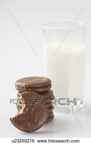 Stock Photograph - Close-up of a glass of milk with chocolate cookies. Fotosearch