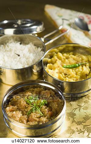 Stock Image - Close-up of an open tiffin with various Indian food. Fotosearch
