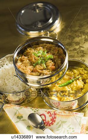 Stock Image - Close-up of an open tiffin with various Indian food. Fotosearch