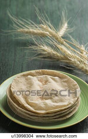 Picture - Close-up of chapattis in a plate with husk of wheat. Fotosearch