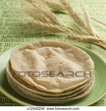 Stock Photograph - Close-up of chapattis in a plate with husk of wheat. Fotosearch