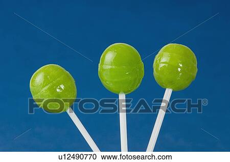 Close-up of three green lollipops View Large Photo Image Stock Image - Close-up of three green lollipops. Fotosearch