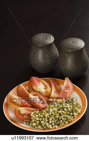 Stock Photo - Close-up of bean sprouts and tomato slices in a plate. Fotosearch
