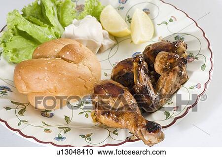 Stock Image - Close-up of roasted chicken and bun with salad in a plate. Fotosearch